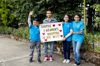 Four children hold a sign that reads "Seattle Children's Hospital is the best!"