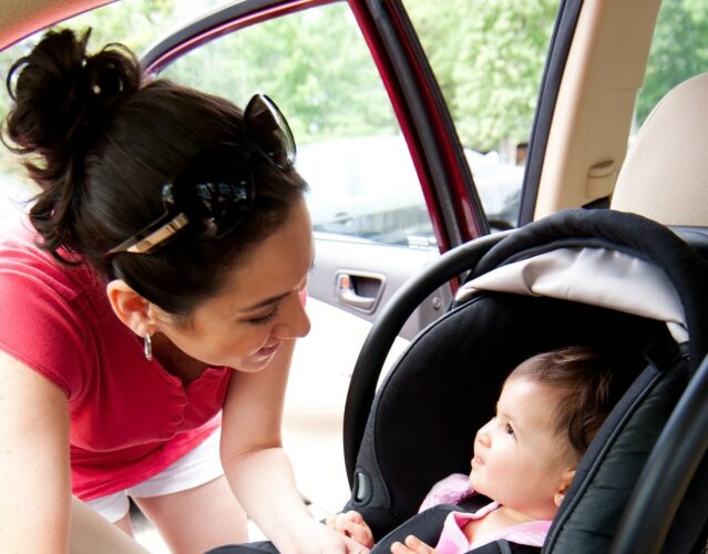 parent smiles at child in carseat