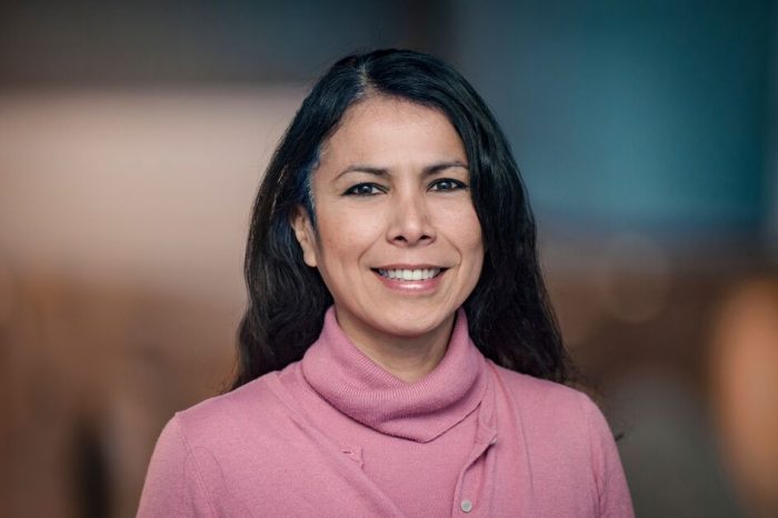 A close up photo of a female doctor smiling at the camera