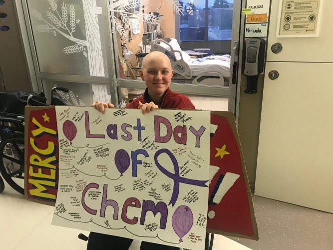 teen holds sign celebrating her last chemo