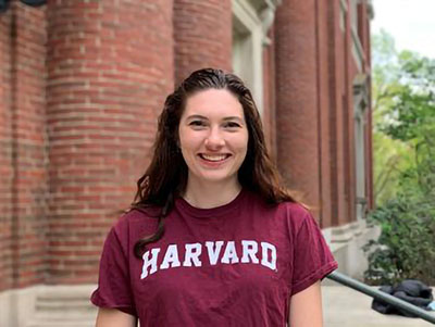 A young woman in a Harvard shirt.