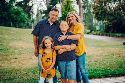 A mother, father, son and daughter pose for the camera