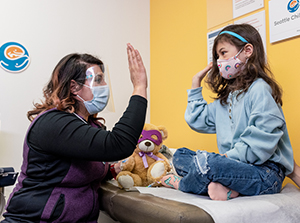 a medical provider gives a little girl a high-five