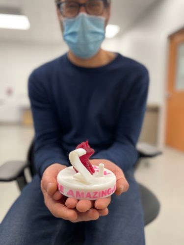 A doctor holding a cake topper