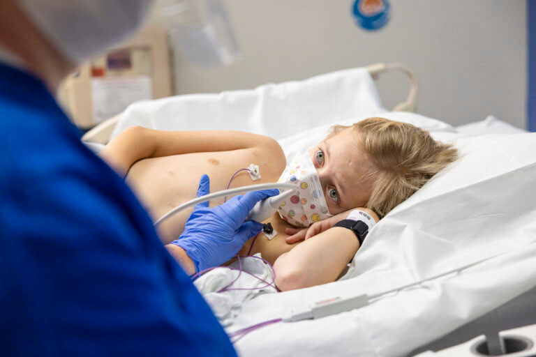 A boy in a hospital bed receives and ultrasound