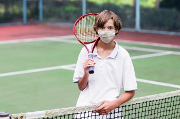 teen boy holding a tennis racket