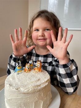 A girl in front of a birthday cake