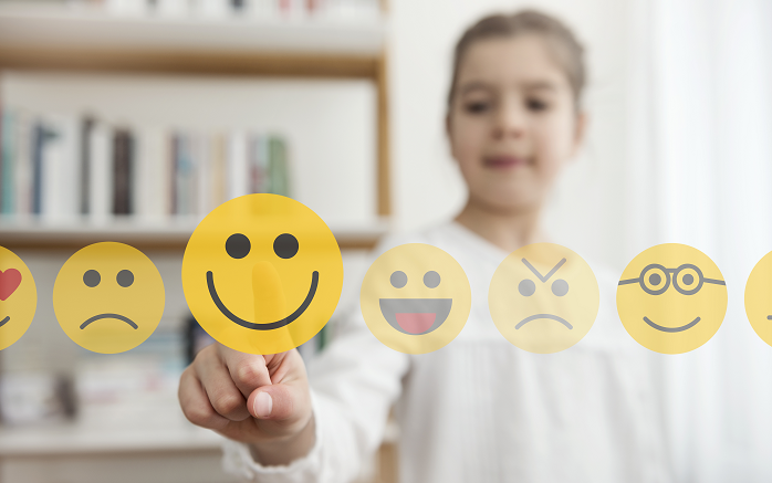 A child chooses their mood by pointing at an emoji.