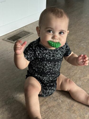 an infant with a teething ring in their mouth