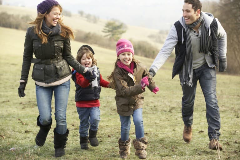 A family running together in a park.