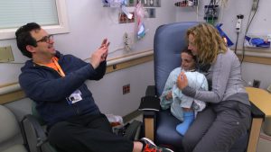 A dad, mom and son sit together in a hospital room