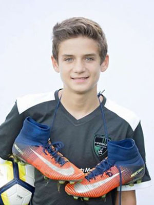 A boy poses with soccer gear