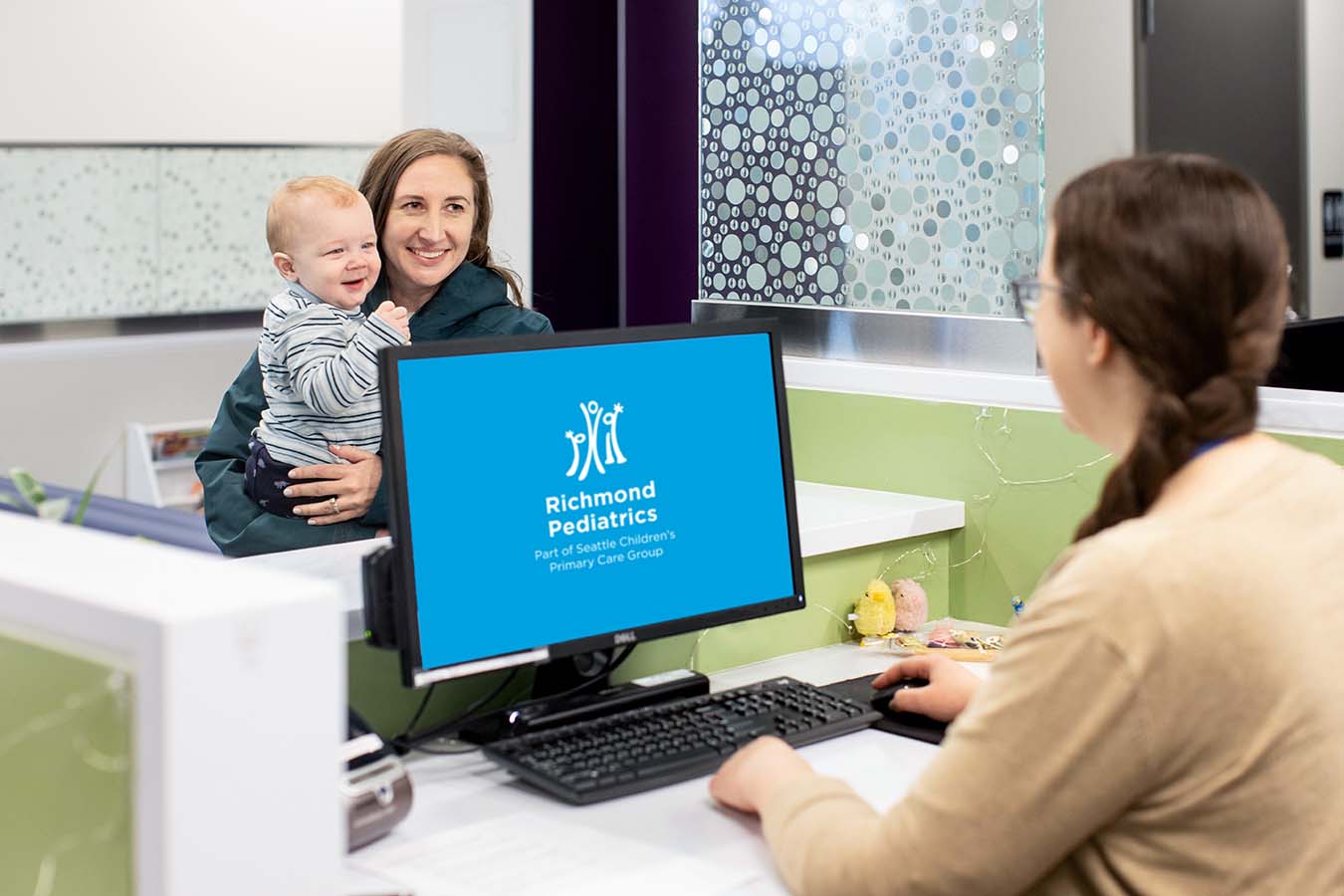 A woman checks in at a clinic's front desk