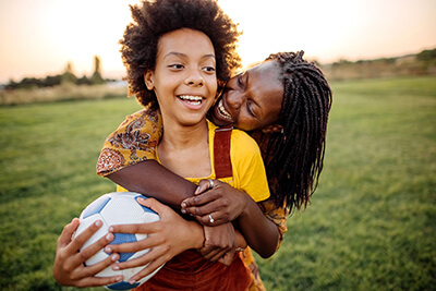 Mother holding son and soccer ball