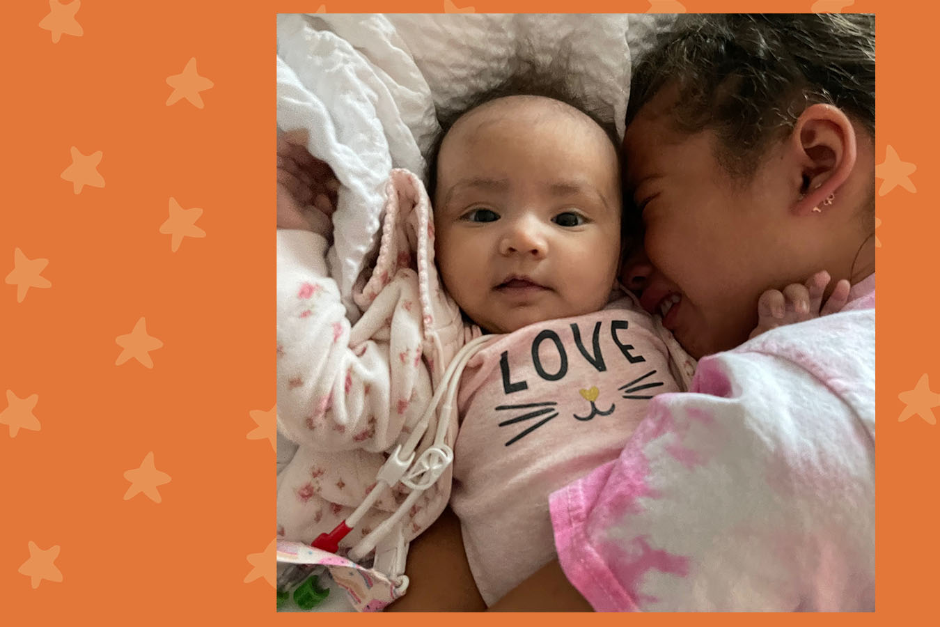 A big sister holds her baby sister on a plane