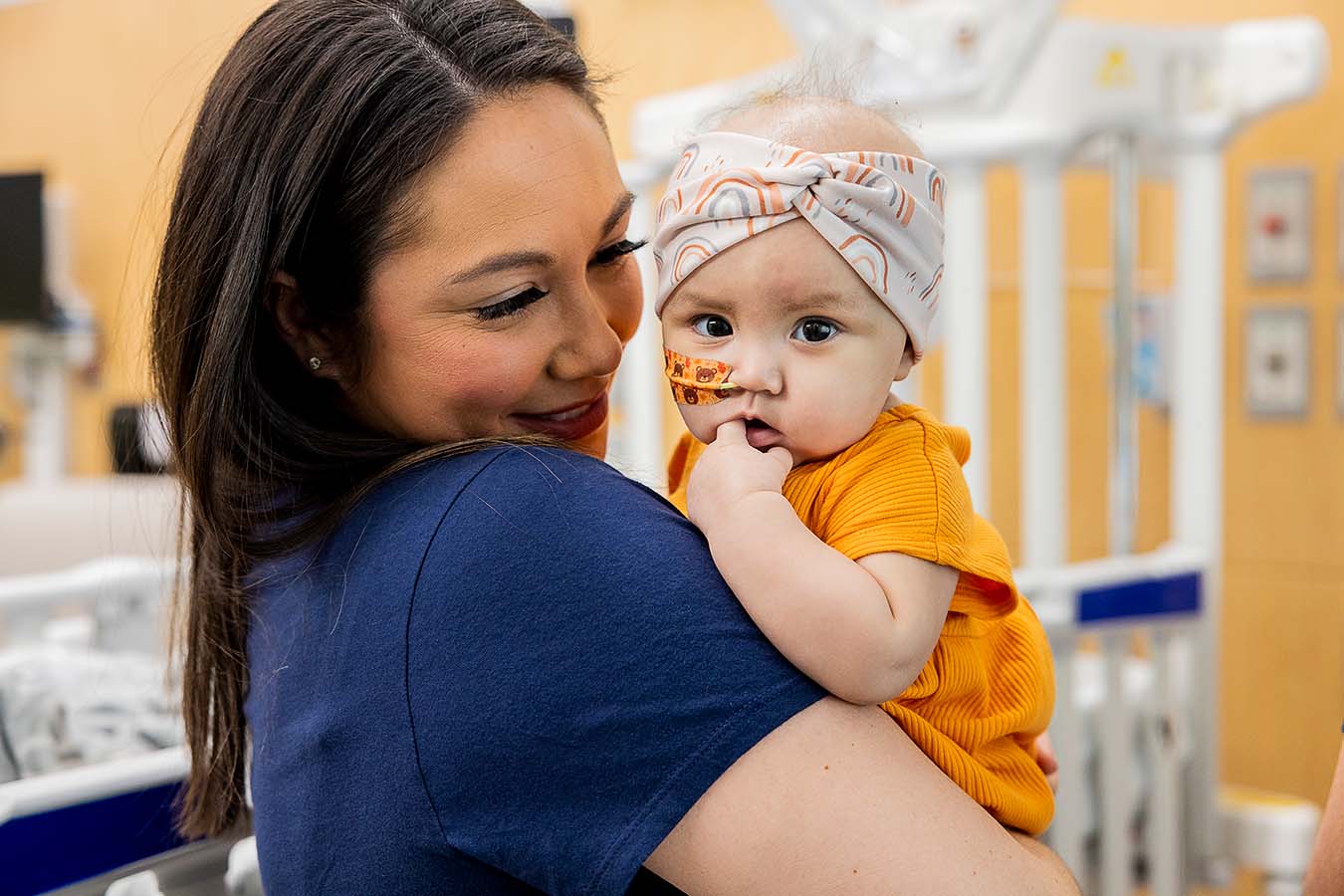 A mother holds her baby in a hospital room