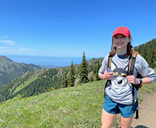 Girl with field and mountains in background