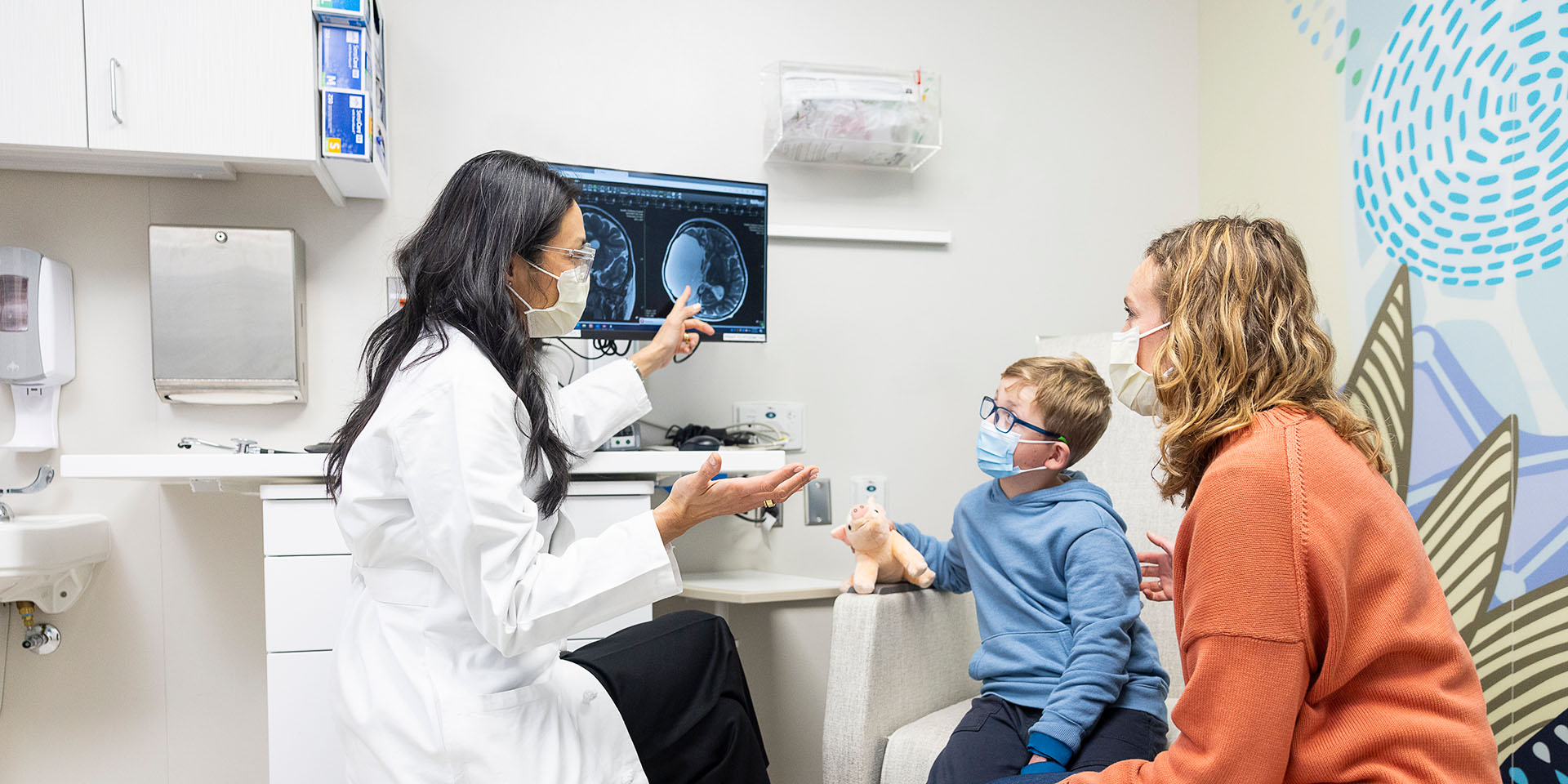 A Seattle Children's doctor speaks with a parent and her son