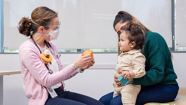 A Seattle Children's doctor speaks with a neurosciences patient and her mother