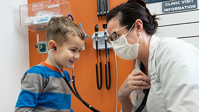 A Seattle Children's provider lets a child listen to their heart through a stethoscope