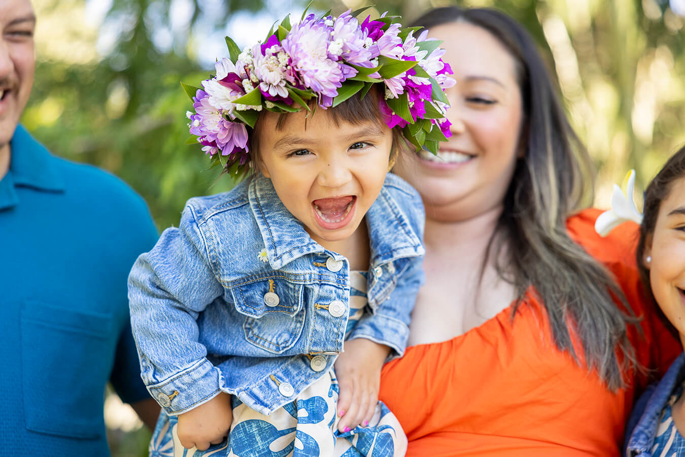 Child with crown of flowers and family