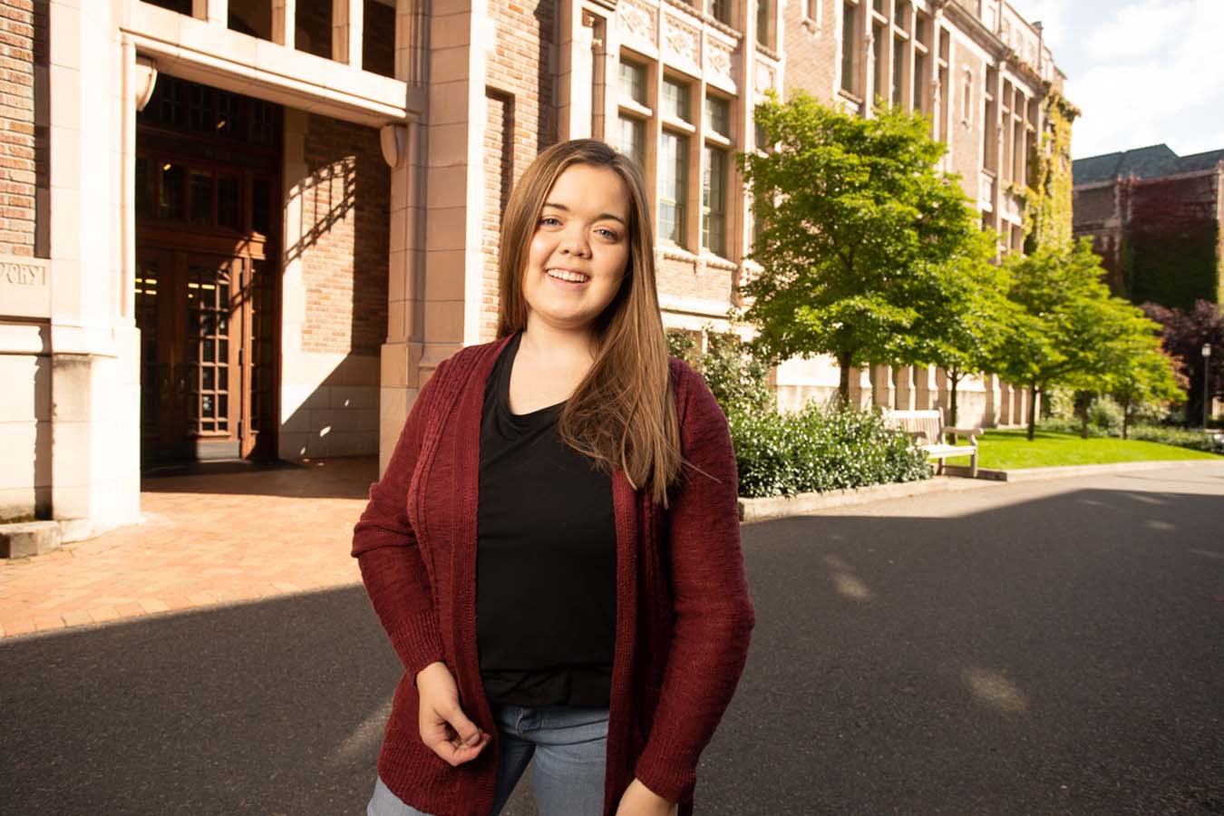 A young woman stands in front of a building