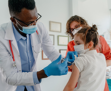 A medical provider gives a patient a flu vaccine in their arm