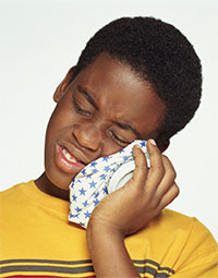 A boy holding an ice pack against his cheek