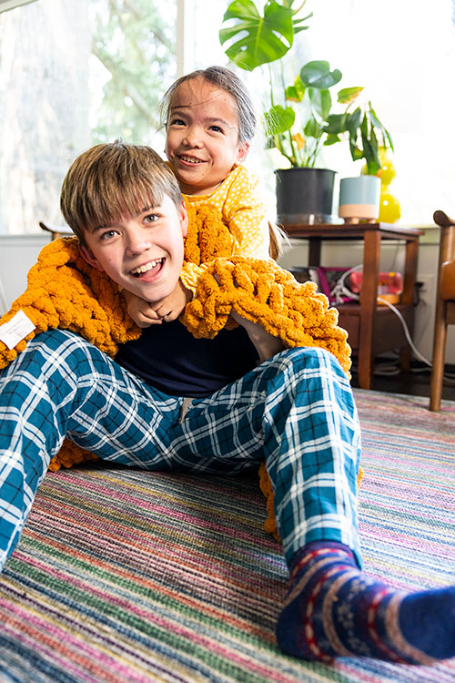 A girl rides on her brother's back