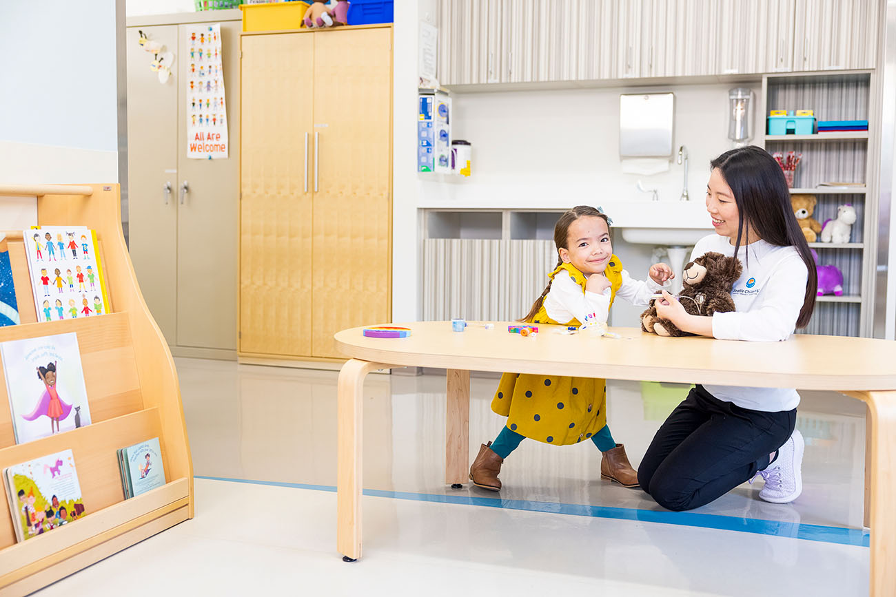 A Seattle Children's patient stands at a table with a provider