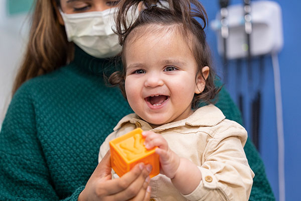 A toddler holds a toy block