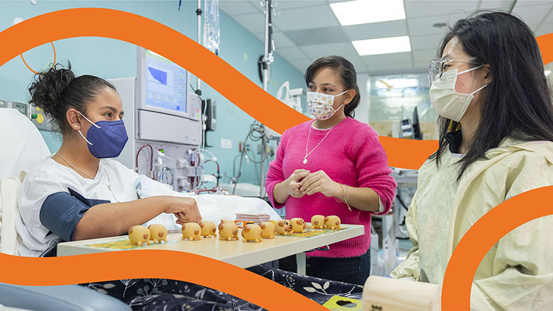 A mother and Seattle Children's provider stand next to a patient's bed