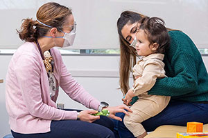 A Seattle Children's provider examines a child in her mother's lap