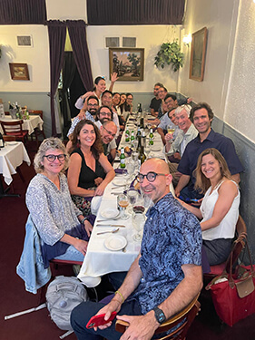 Vitanza Lab team members at table with fellow scientists