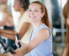 Woman smiles while riding an exercise bike