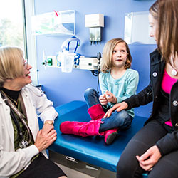 A daughter looks at her mother as they speak with a doctor at Seattle Children's