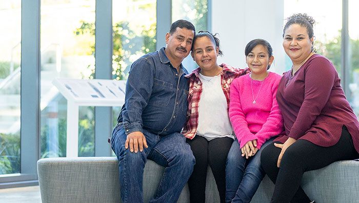 A mother, father and two girls pose for the camera