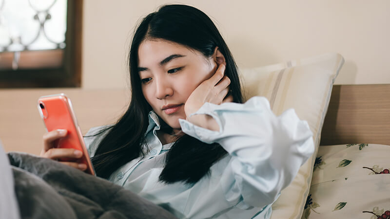 Asian woman looking at cell phone